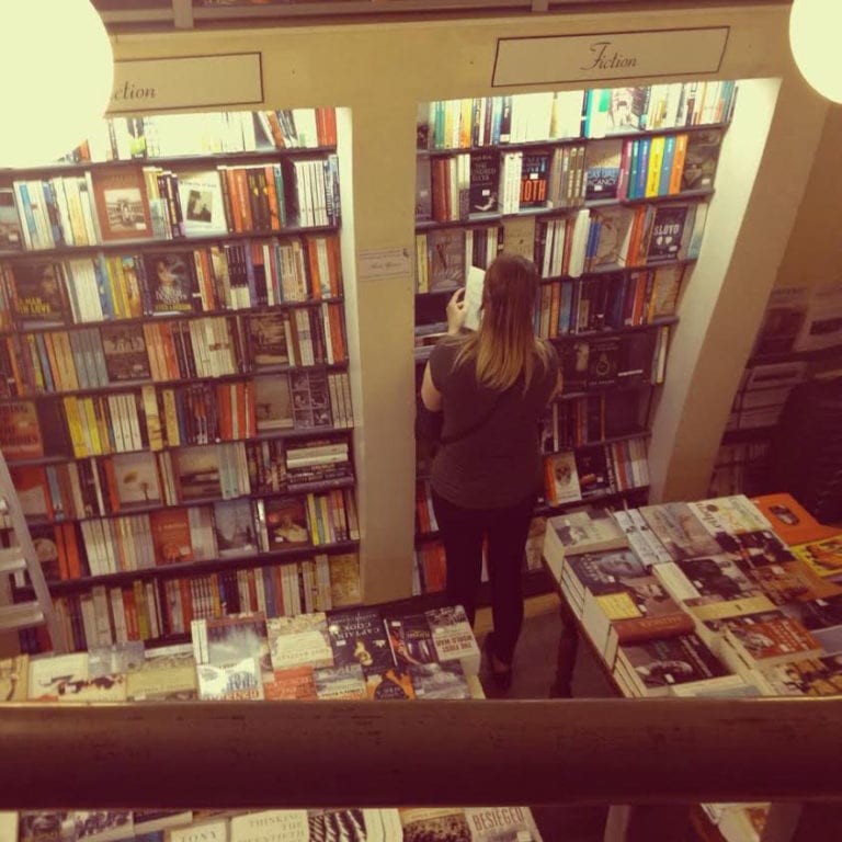 Woman searching for books in a bookstore
